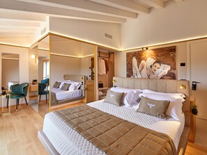 A modern hotel room with a large bed, a sitting area, and a mirror. - Forte Benedek Wine Relais & SPA - Adults Only (Pastrengo)