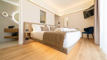 Ein modernes Schlafzimmer mit Bett, Nachttischen, Fernseher und Spiegel.