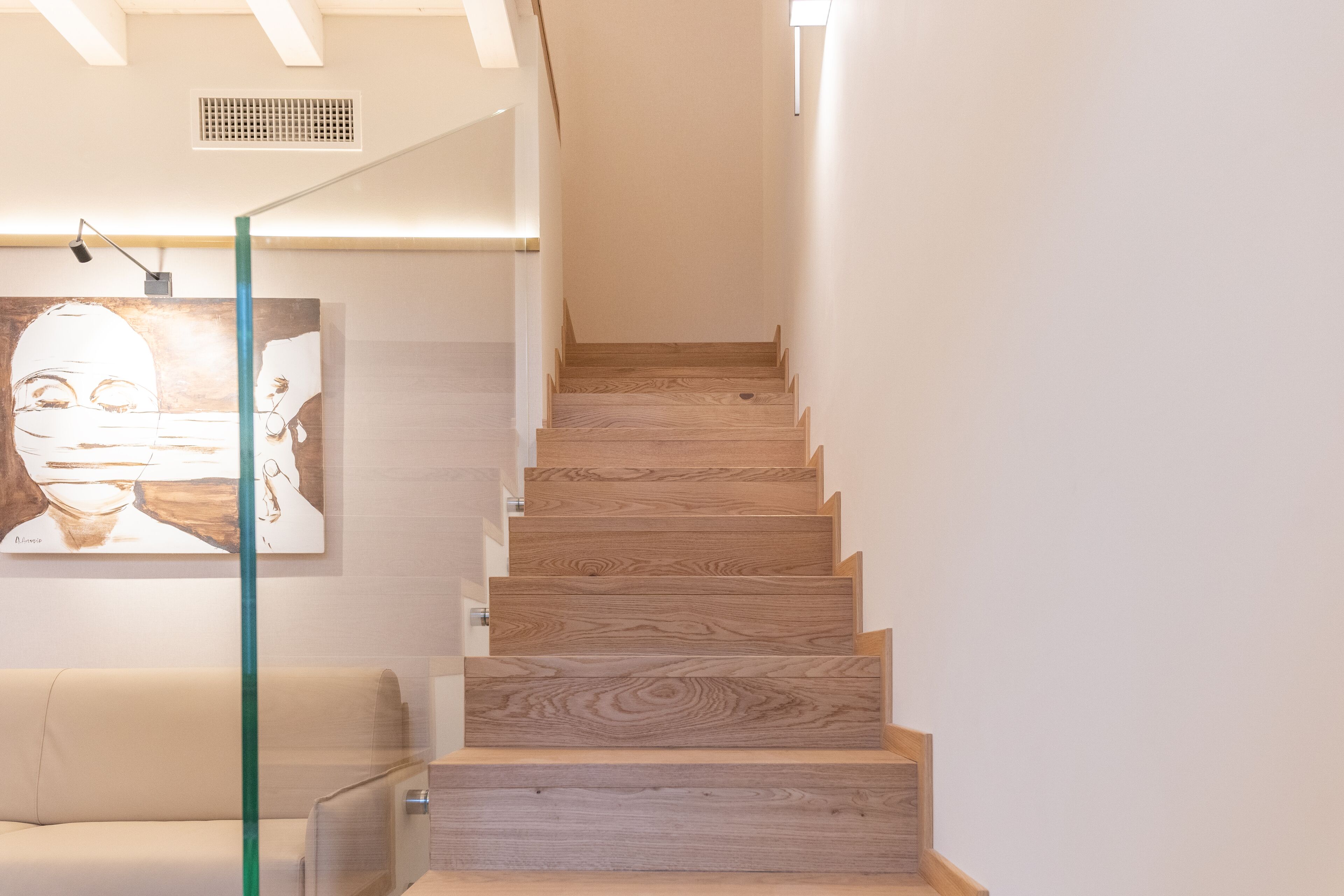A staircase with wooden steps and a glass railing.