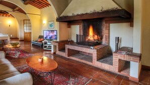 Una sala de estar acogedora con chimenea, televisor y comedor.