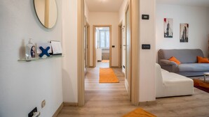 Een hal met een spiegel, een plank met toiletartikelen, een bank en een vloerkleed.