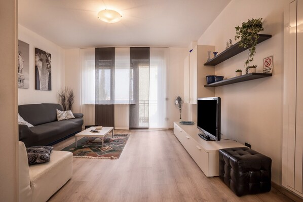 Un salon moderne comprenant un canapé, une table basse, un téléviseur et des objets décoratifs.
