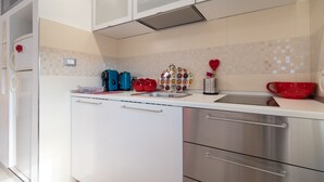 Una cocina moderna con armarios blancos, electrodomésticos de acero inoxidable y un salpicadero de azulejos.
