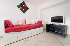 Ein modernes Schlafzimmer mit Bett, Fernseher und Stauraum.