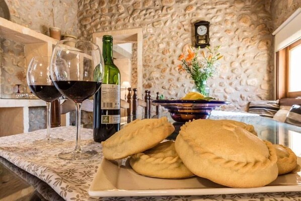 Une table avec une bouteille de vin, deux verres de vin rouge et une assiette de pâtisseries.