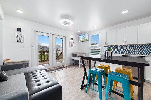Relax in a comfortable living space with a sofa and ottoman, adjacent to a well-equipped kitchen and dining area.