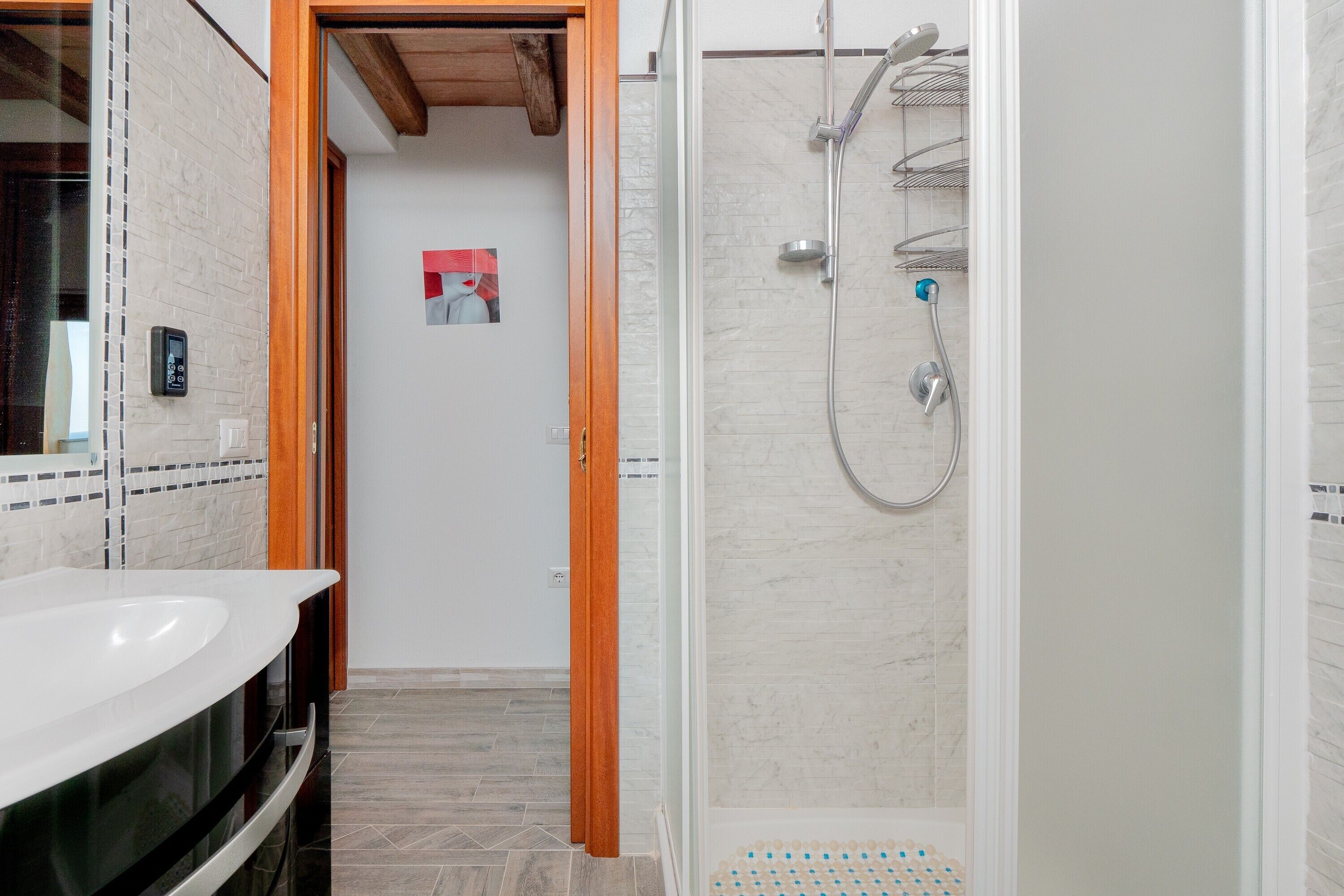 Une salle de bain moderne avec une douche, un lavabo et un miroir.