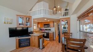 A spacious kitchen with wooden cabinets, a central island, and a dining area with chairs. - Gold Medal Trout Fishing at the Door - 2BR Cabin, 22mi to Breckenridge (Fairplay)