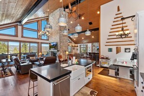 A spacious kitchen with a large island, wooden flooring, and a stone accent wall.