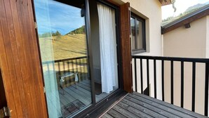 A wooden deck with a glass door leading to a balcony. - Duplex T2 apartment on slope for 6 people with ski box in Super-Sauze (Enchastrayes)