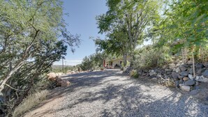 A gravel driveway leading to a house with a stone wall on one side and trees on the other. - Vineyard Views & Sauna at Cornville Home! (Cornville)
