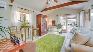 A spacious living room with a wooden ceiling, a green rug, a chessboard, and a sofa. - Vineyard Views & Sauna at Cornville Home! (Cornville)