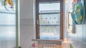 A bathroom with a toilet, sink, and window. - IL TASSO           . (Castiglione del Lago)