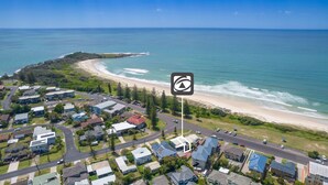An aerial view of a coastal residential area with houses, a beach, and a clear view of the ocean. - Pippis on Pacific - fantastic two-level townhouse located opposite Yamba's beautiful Pippi Beach (Yamba)