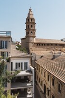 Un edificio histórico con una torre de campanas, un patio interior y edificios modernos adyacentes.
