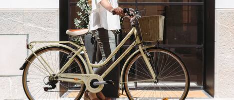 Un vélo ancien, doté d’un panier et d’une selle, est garé sur un trottoir.