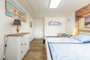 A bedroom with a bed, bedside table, lamp, and a painting on the wall. - "Landliebe" Vacation Rental in Husum-Schauendahl for up to 4 people (Husum-Schauendahl)