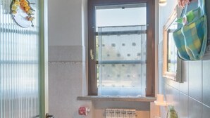 Une salle de bain avec des toilettes, un lavabo et une fenêtre.