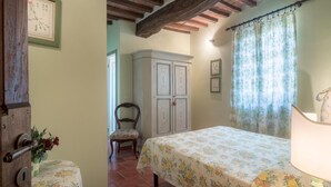 Une chambre à coucher avec un lit, une chaise, une armoire et une lampe.