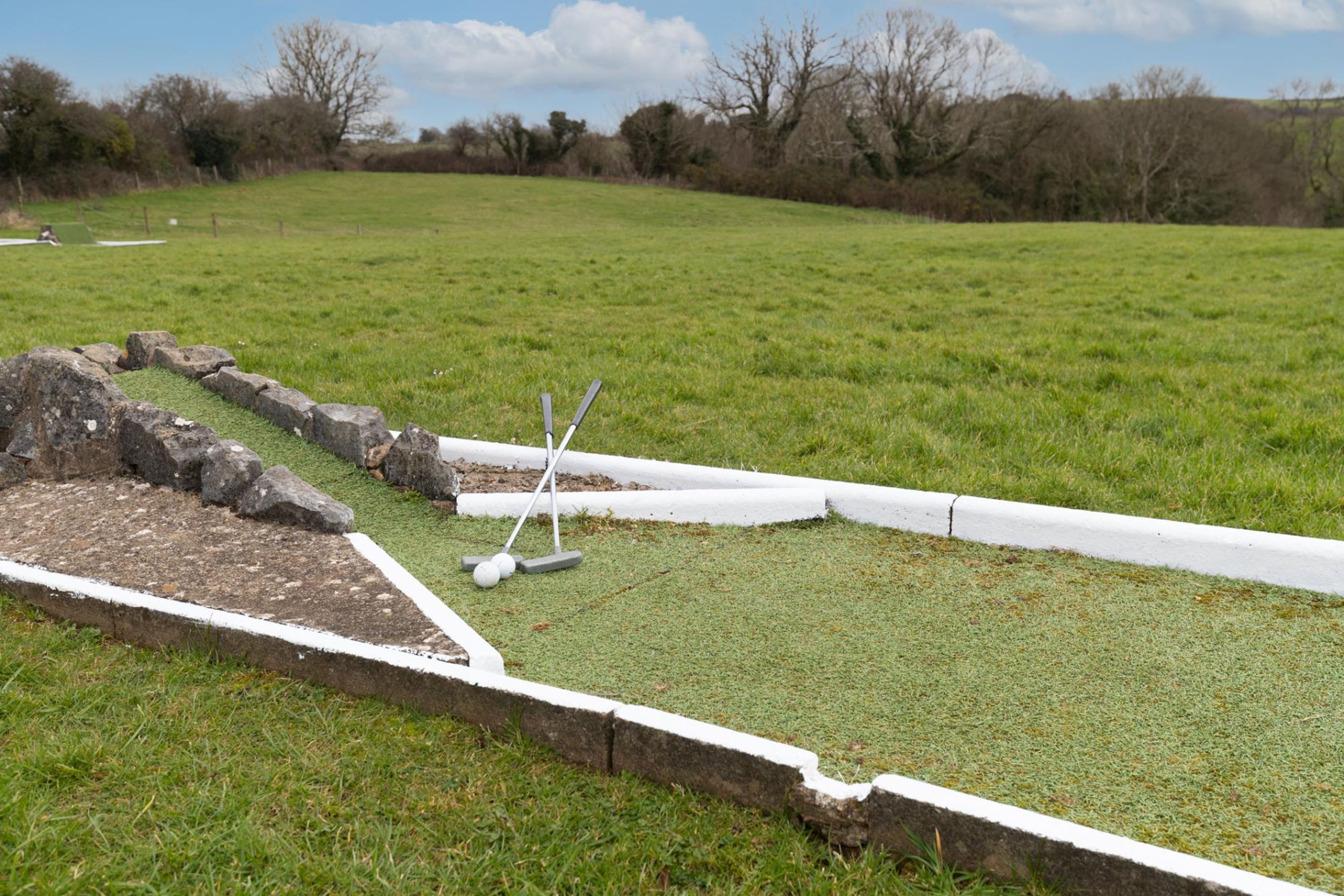 Ein grünes Feld mit einem Croquet-Set.