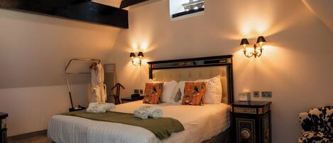 Une chambre à coucher avec un grand lit, un lustre, des appliques murales, un miroir et une petite fenêtre.
