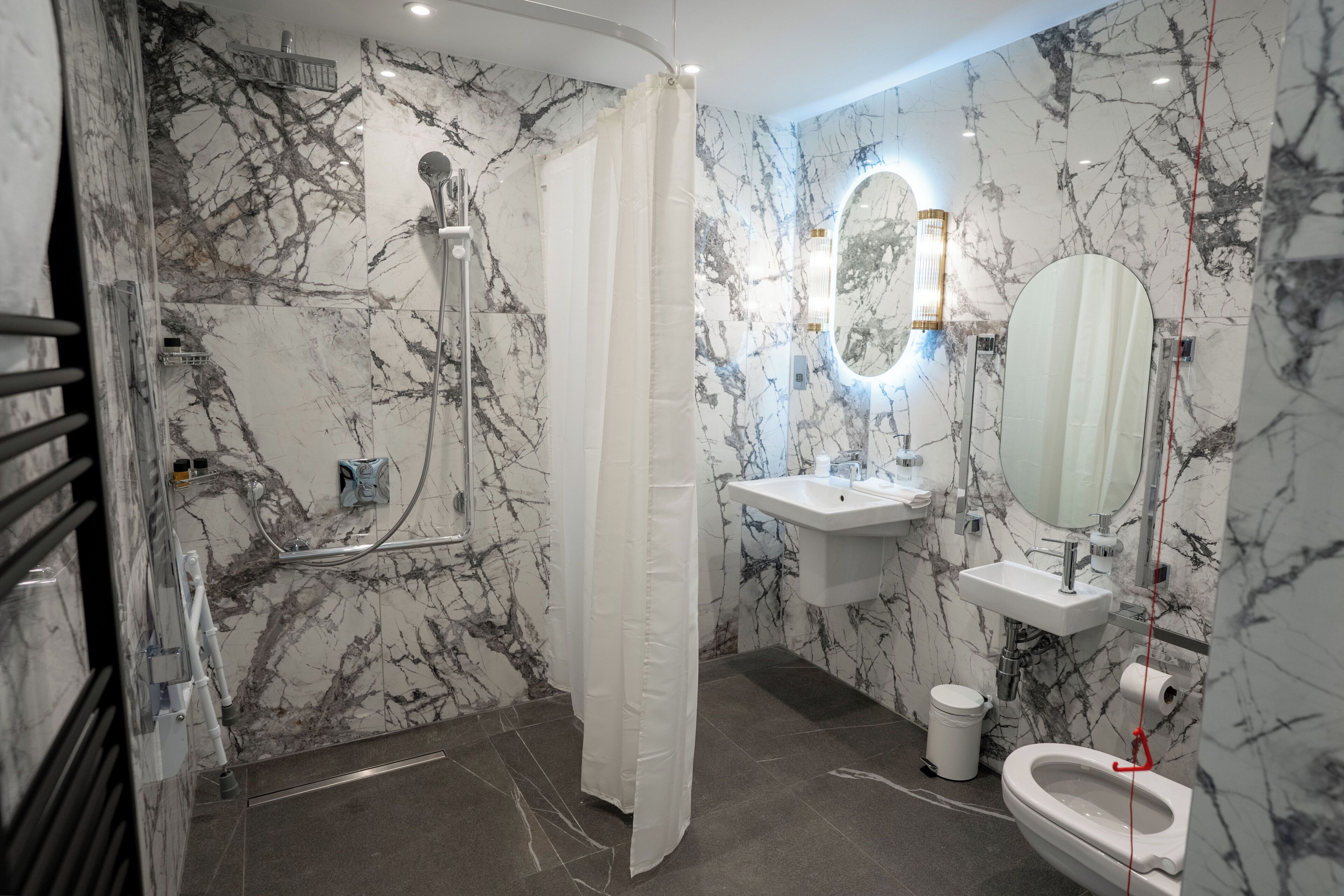 Un baño con ducha, inodoro, lavamanos y espejo.