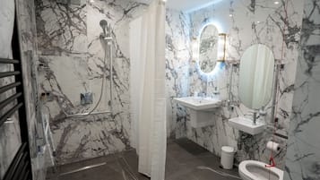 Un baño con ducha, inodoro, lavamanos y espejo.