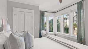 A bedroom with a large bed, a chair, and a window with curtains. - New Reno!- Steps to Beach- Elevator- Golf Cart (Santa Rosa Beach)