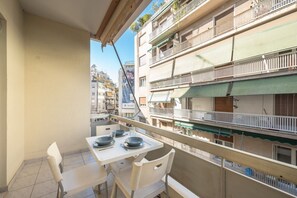 Enjoy dining or socializing on this spacious balcony with a table set for meals.