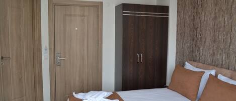 Una habitación de hotel con una cama, un armario de madera y un vestidor amplio con espejo.