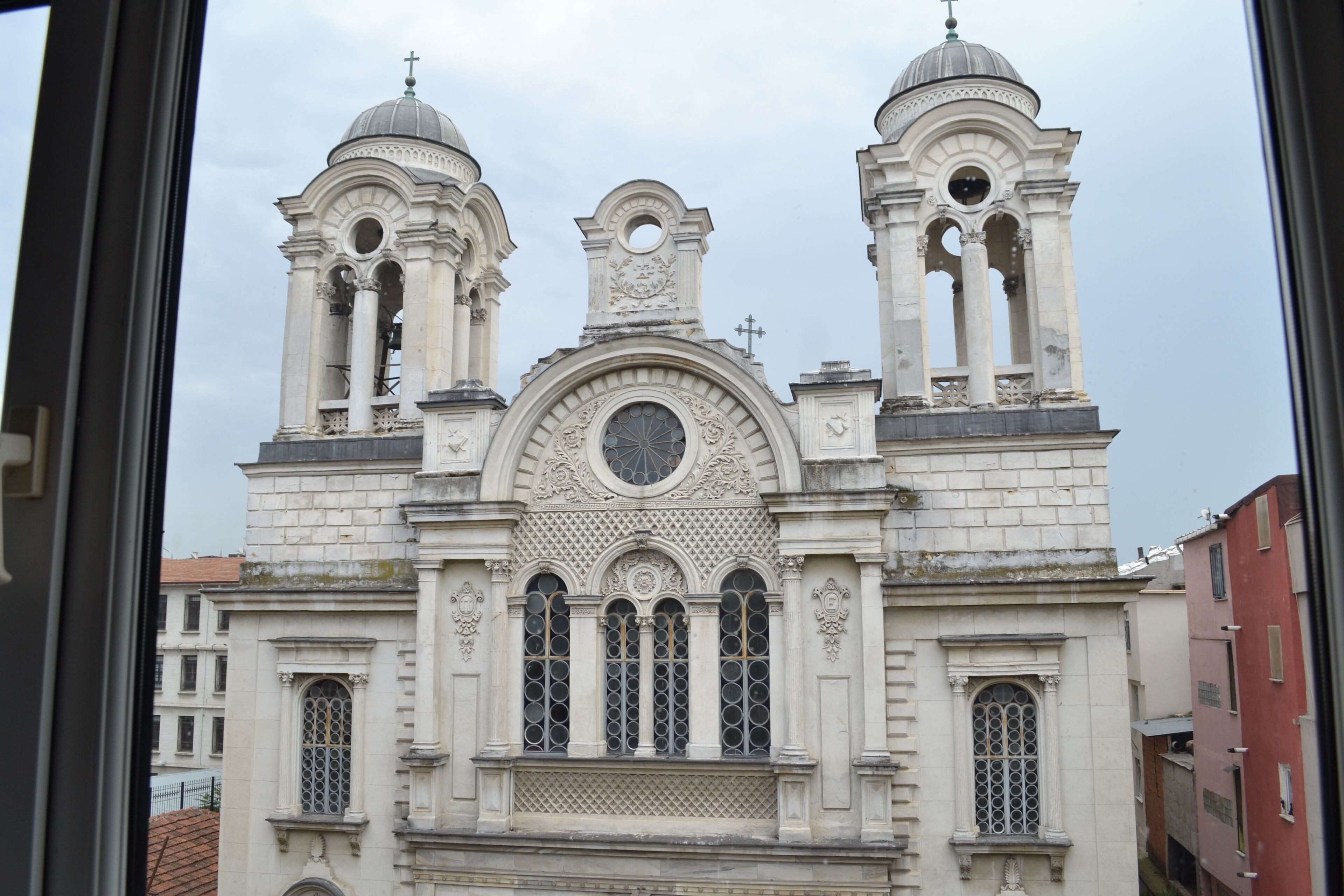 Un edificio histórico con dos torres destacadas, una cúpula central y varios ventanales de arco.