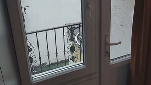 A room with a sliding glass door leading to a balcony with a metal railing. - Global 2022 Hotel (Istanbul)