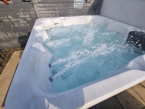 Ein Whirlpool mit klarem Wasser, Metallrahmen und einem Schild an der Wand.