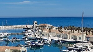 A marina with numerous boats docked, a small building with a tower, and a clear blue sky. - B&B in the wonderful and evocative center of Rodi Garganico (Rodi Garganico)