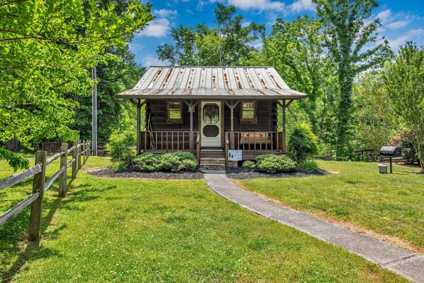 A rustic cabin with a metal roof, wooden porch, and a pathway leading to it. - Riverfront, ½ Mile to Smoky Mtn National Park (Townsend)