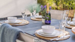 Ett dukat bord för en måltid med en flaska Pommery-champagne, vita tallrikar och klara glas.