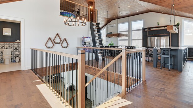 A spacious interior with a wooden staircase, a mezzanine level, and a kitchen area. - Domaine Des Mésanges (Beaupré)