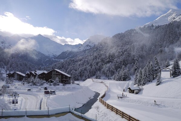 A snow-covered mountain resort with wooden cabins and a small lodge.