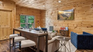Ein Holzinterieur mit Barbereich, Sitzgelegenheiten und einem großen Fenster.