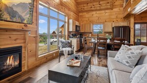 Eine geräumige Holzhütte mit großem Essbereich, Küche und Wohnzimmer.