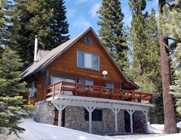 A cabin with a stone foundation, wooden exterior, and a balcony with wooden railings. - Mountain Getaway w/ Granny Unit, Dogs Ok #47 by Bear Valley Vacation Rentals (Arnold)