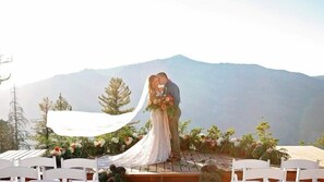Una ceremonia de boda con montañas al fondo.