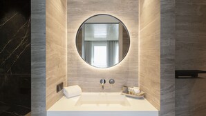 A modern bathroom with a large mirror, a white sink, and a towel. - Legend Hotel (Cologne)
