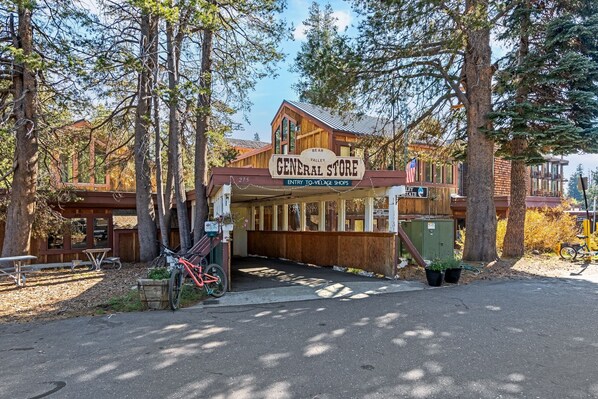 Una tienda rústica llamada 'General Store' con fachada de madera, ubicada en una zona boscosa.