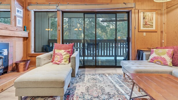 A cozy living room with a sofa, a wooden coffee table, and a patterned rug. - Modern & Sleek Condo - Creekside #110 by Bear Valley Vacation Rentals (Arnold)