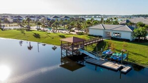 A waterfront property with a dock, a covered area, and a swimming pool. - 5 bedroom home is ideal for an elegant vacation 5 Villa by RedAwning (Kissimmee)