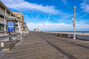 A wooden boardwalk leading to a beach with a clear sky. - Short Walk to Beach and Boardwalk with a Pool (Ocean City)
