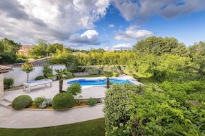 A backyard with a swimming pool, a billiards table, and a well-maintained lawn.