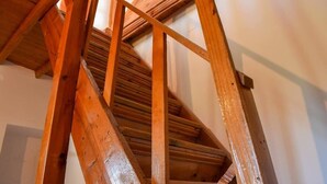 A wooden spiral staircase with a handrail, leading to an upper floor. - Eleni's Coastal Retreat with Ocean View Gemstone (Kalamata)