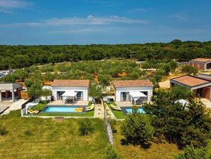 Une villa moderne dotée d’une piscine, de deux chambres d’hôtes séparées et d’un jardin luxuriant.